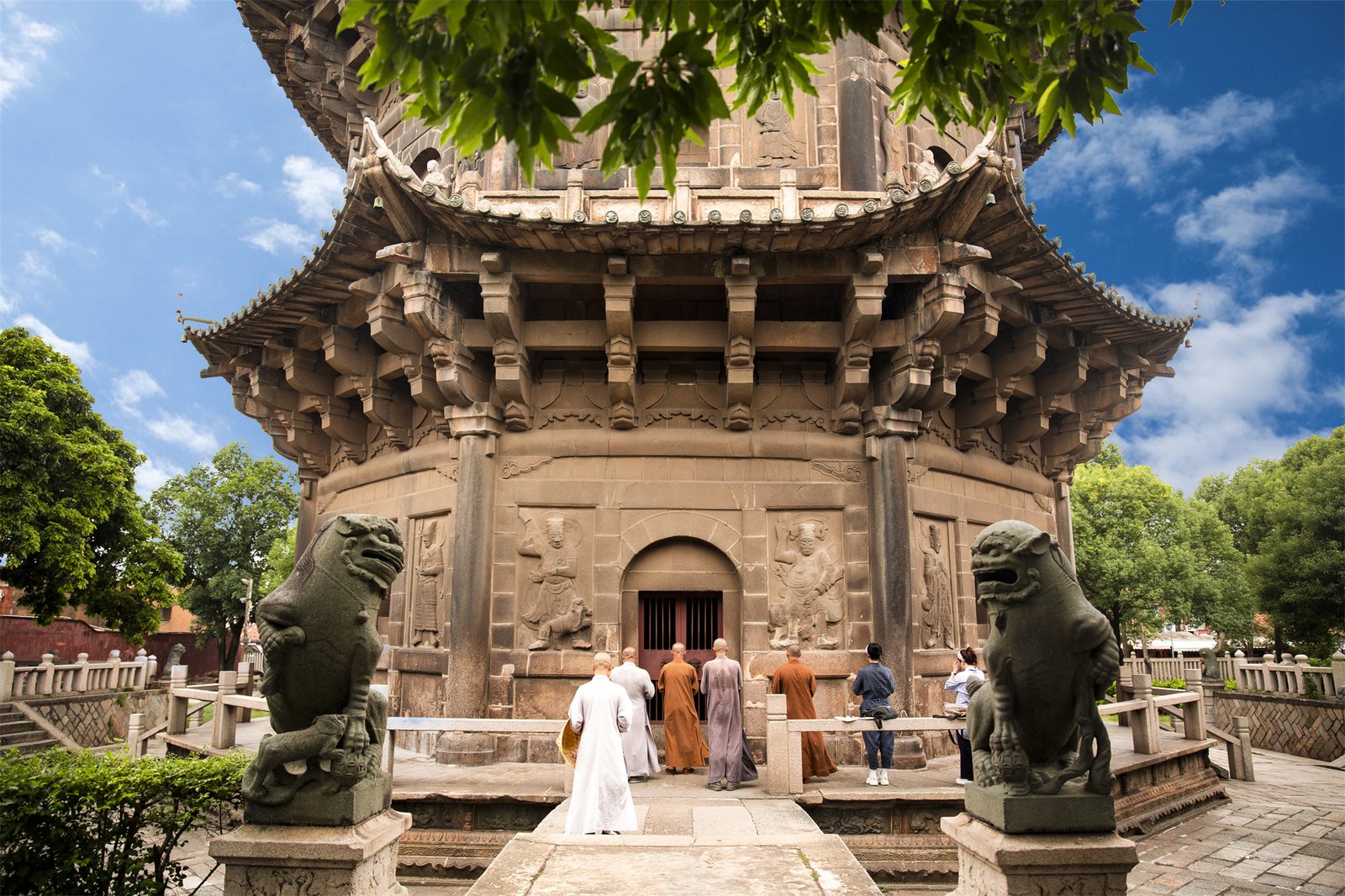 泉州开元寺内的石塔塔基与浮雕，僧人从塔前走过