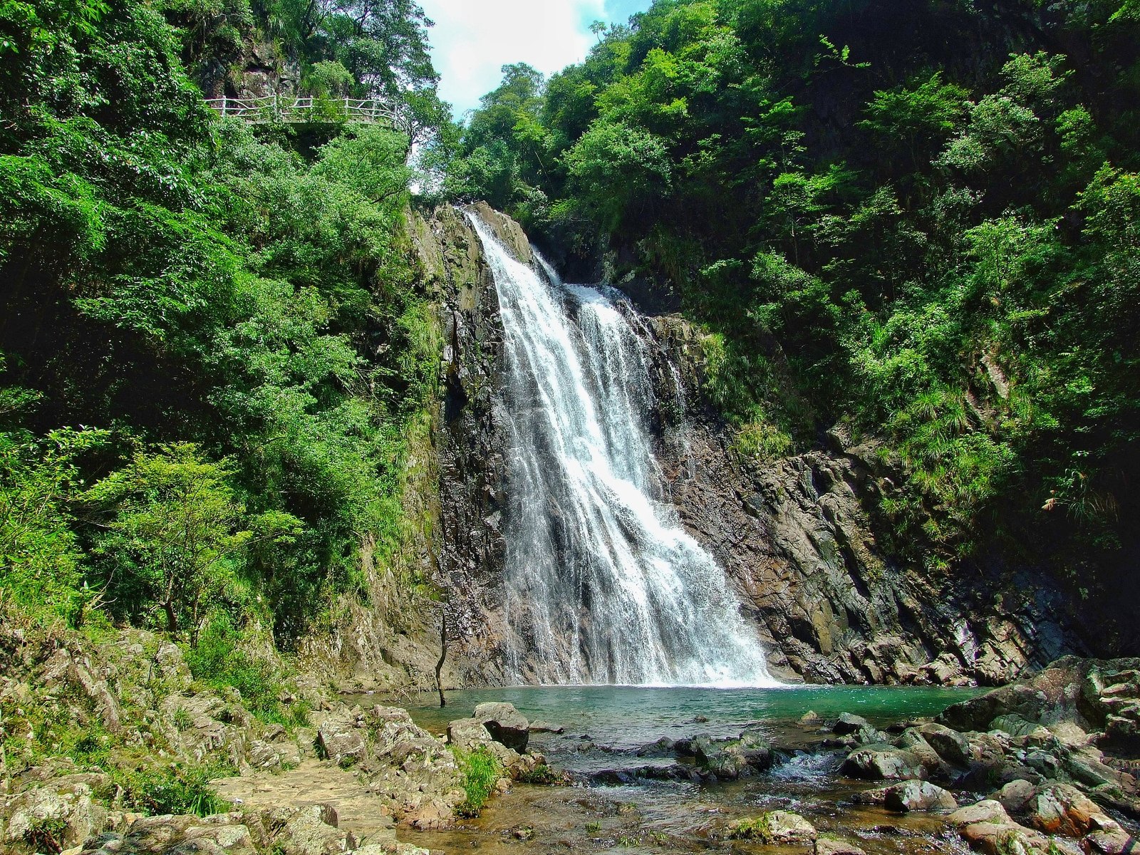 武夷山大安源溪谷里的多级瀑布，水流从岩壁落下汇入清澈的潭水