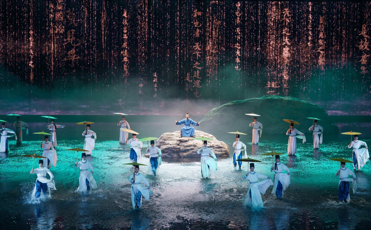 武夷山夜间水舞台实景演出，演员持伞在浅水中列队